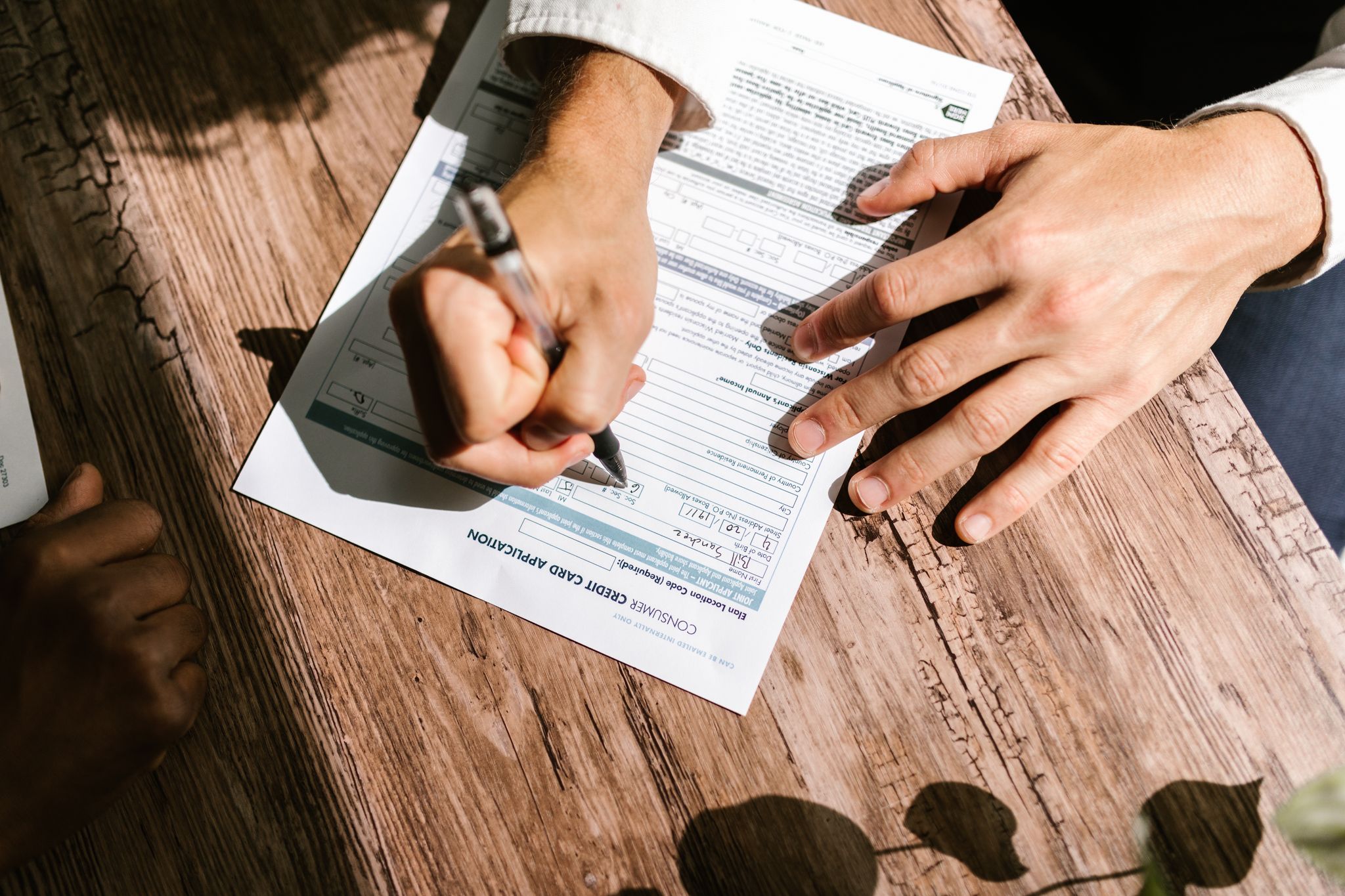 Hands completing loan documents during a mobile notary appointment in Arizona